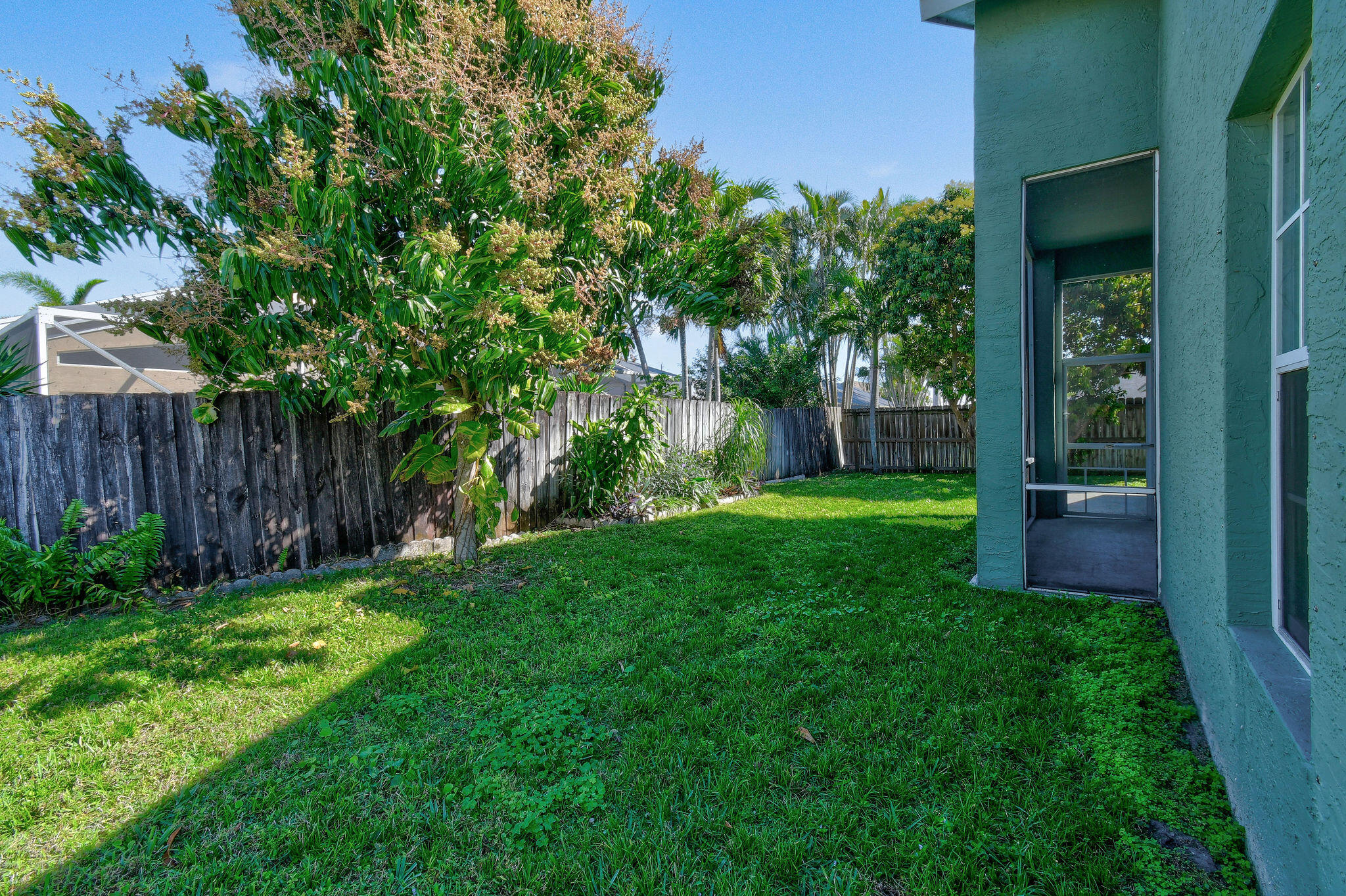 6293 Michael Street Jupiter, FL 33458 - Photo 43 of 64 a view of a backyard with table and chairs and wooden fence