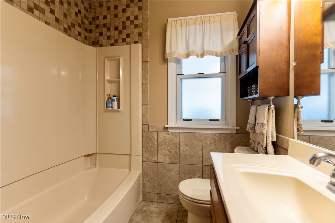 1400 East Miner Road Cleveland, OH 44124 - Photo 14 of 25 Bathroom with tile walls, tile patterned flooring, vanity, and toilet