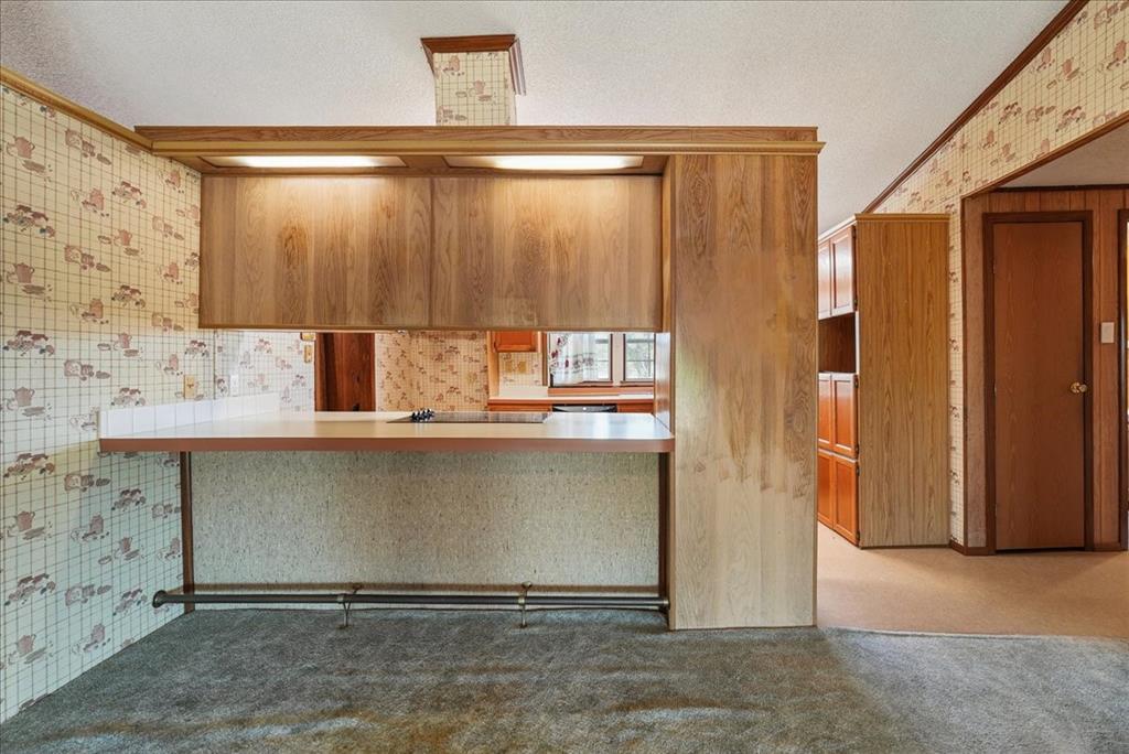 1453 Joyce Road Kaufman, TX 75142 - Photo 20 of 40 Built-in bar with overhead cabinetry, integrated lighting, and a foot rail
