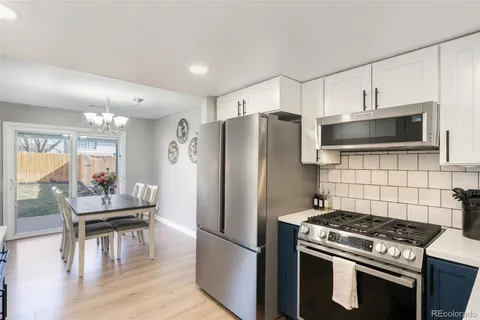 a kitchen with granite countertop a refrigerator stove and microwave