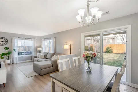 a view of a dining room with furniture a chandelier and wooden floor