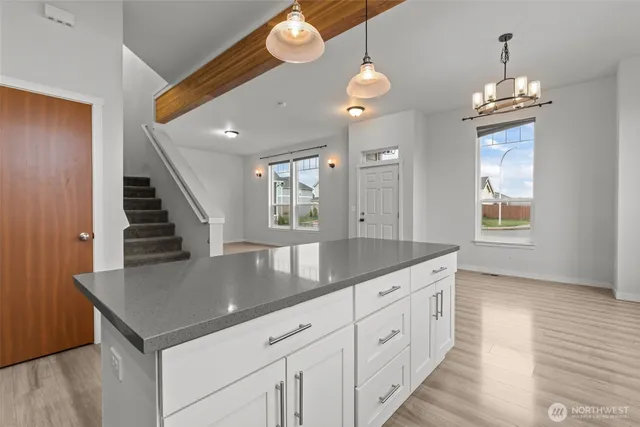 a kitchen with stainless steel appliances granite countertop a sink a microwave cabinets and a large window