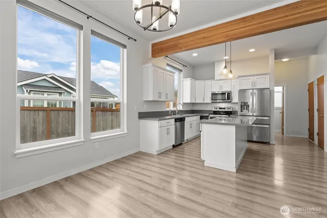a kitchen with white cabinets and appliances