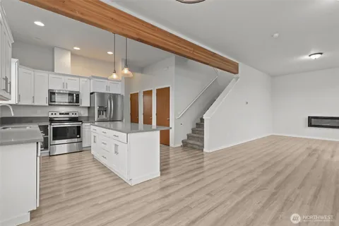 a kitchen with stainless steel appliances kitchen island granite countertop a stove a sink and a refrigerator