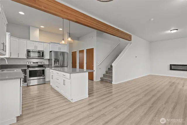 a kitchen with stainless steel appliances kitchen island granite countertop a stove a sink and a refrigerator