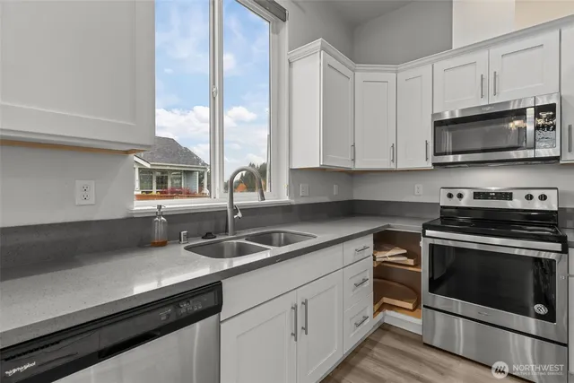 a kitchen with granite countertop a sink stainless steel appliances and cabinets