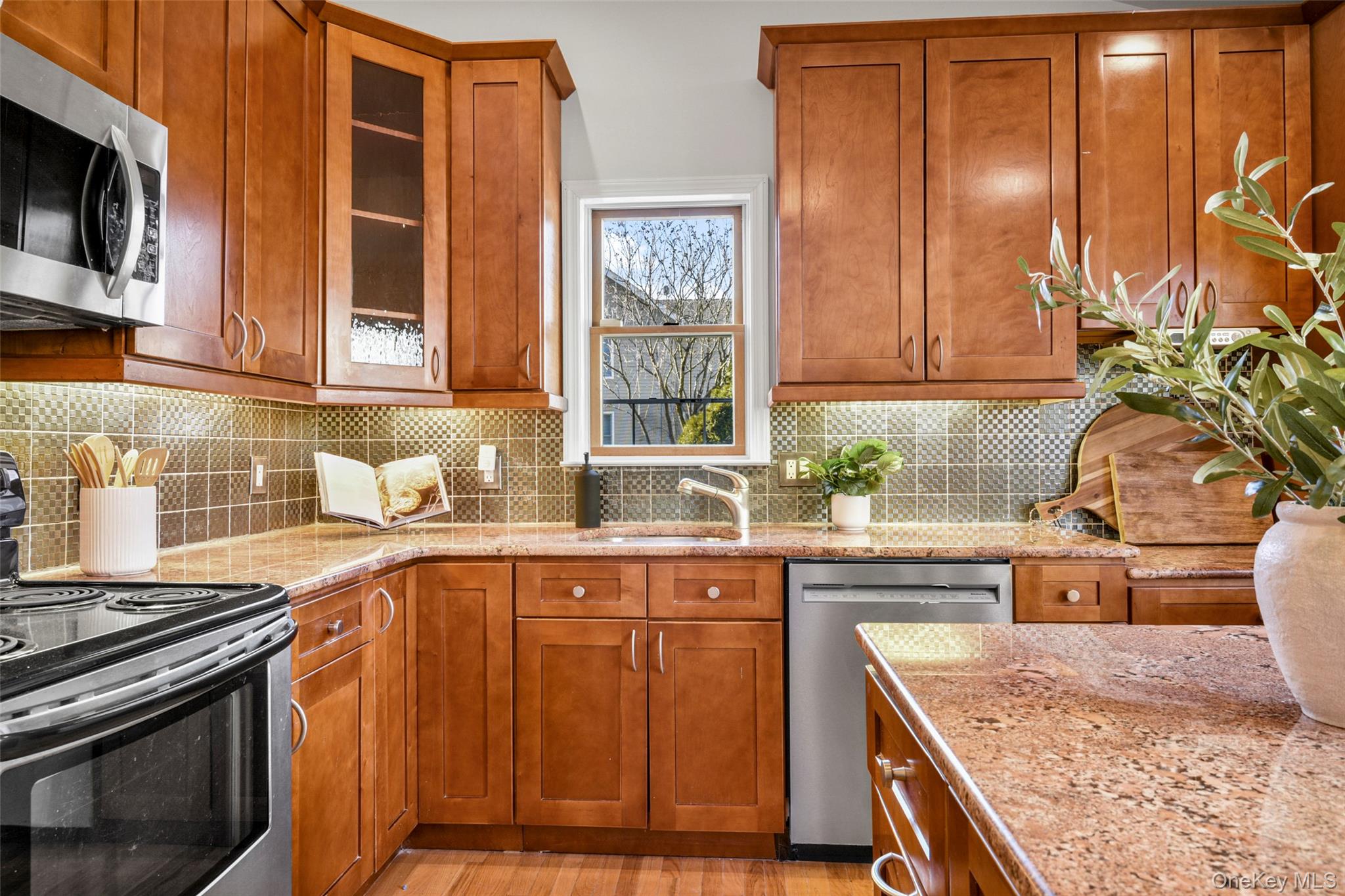 103 Old White Plains Road Tarrytown, NY 10591 - Photo 19 of 37 a kitchen with stainless steel appliances granite countertop wooden cabinets a sink and a stove