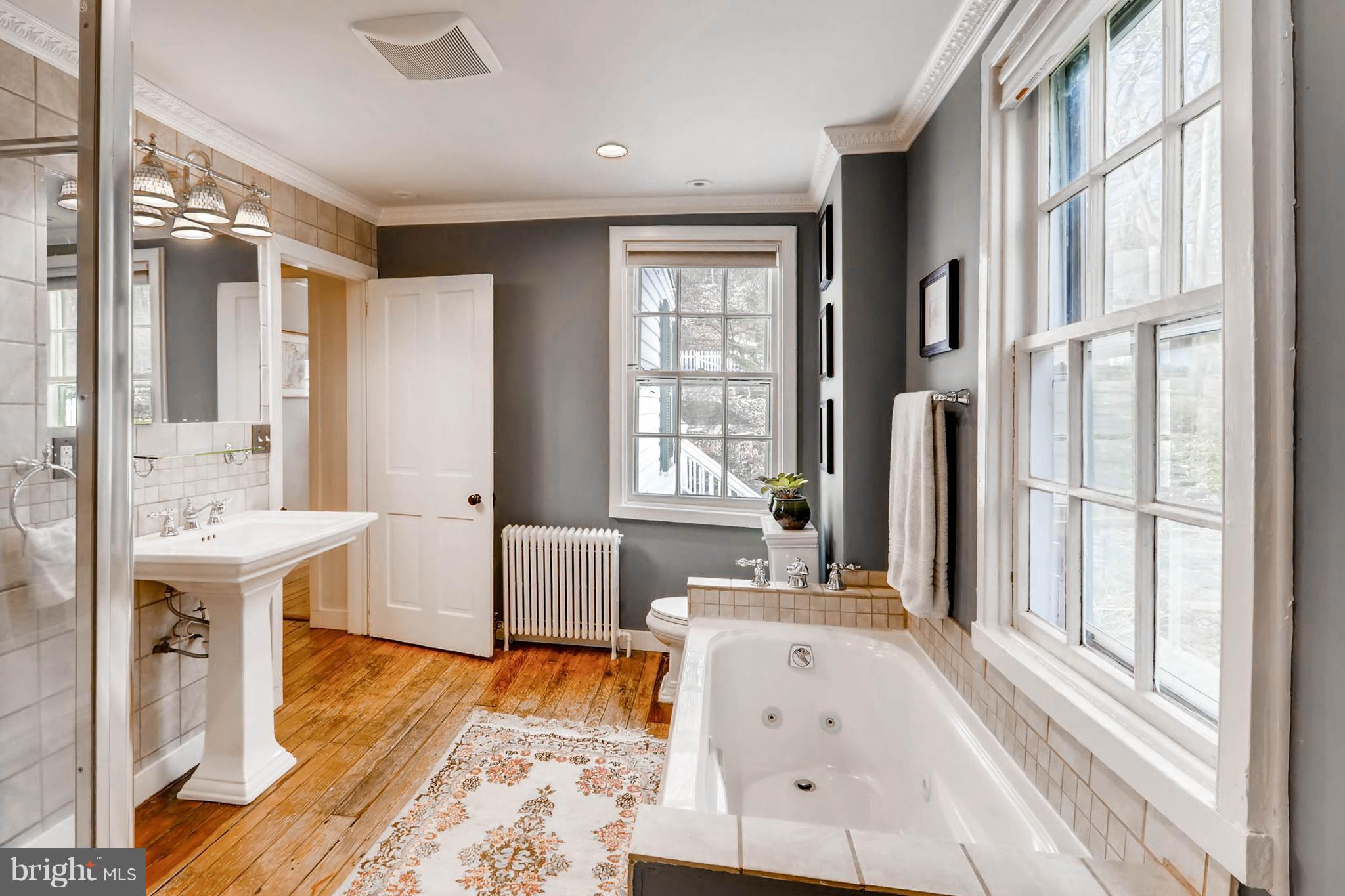 2326 Pickwick Road Baltimore, MD 21207 - Photo 18 of 30 a spacious bathroom with a tub sink and mirror