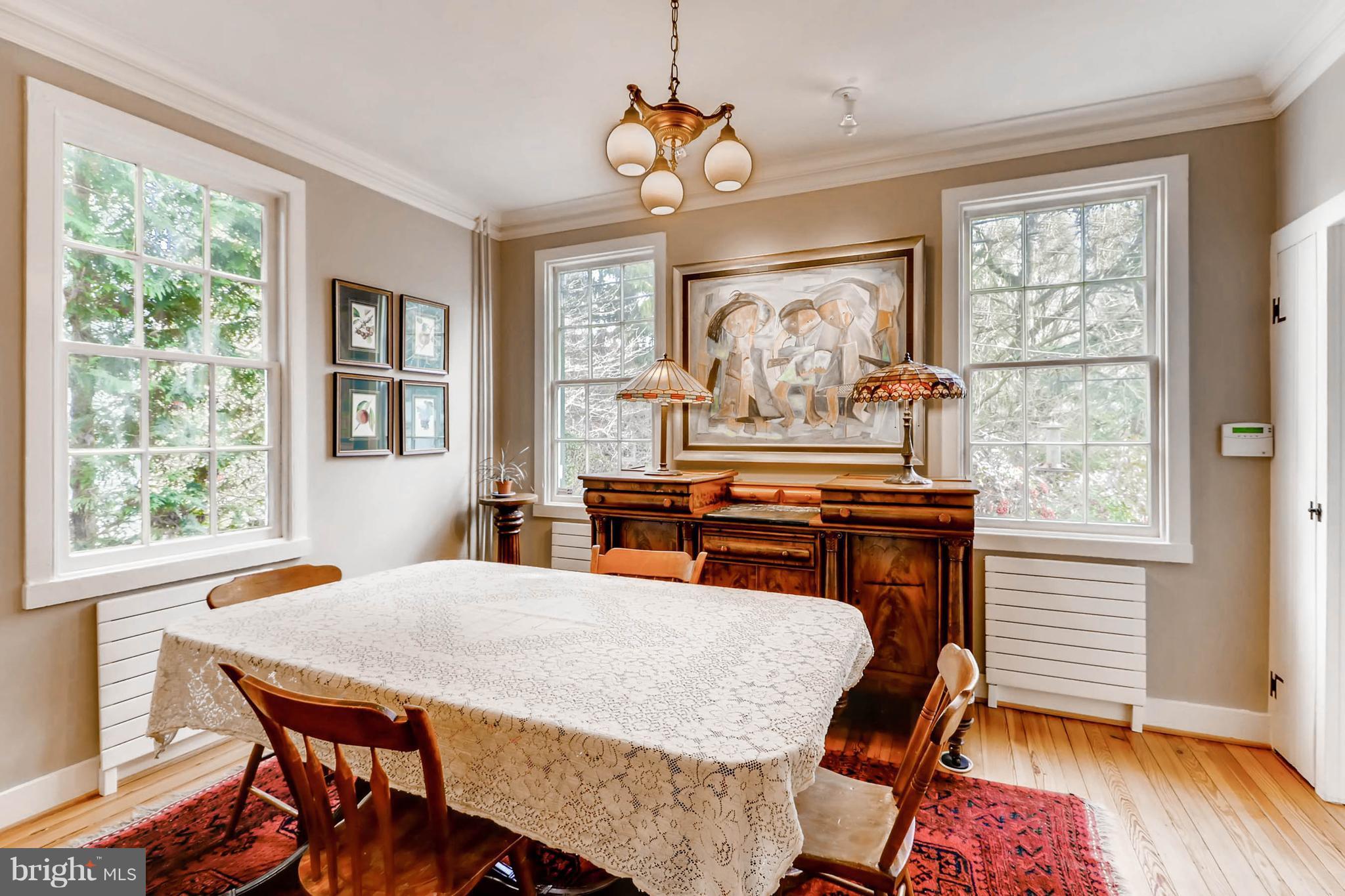 2326 Pickwick Road Baltimore, MD 21207 - Photo 7 of 30 a dining room with wooden floor a chandelier a wooden table and chairs