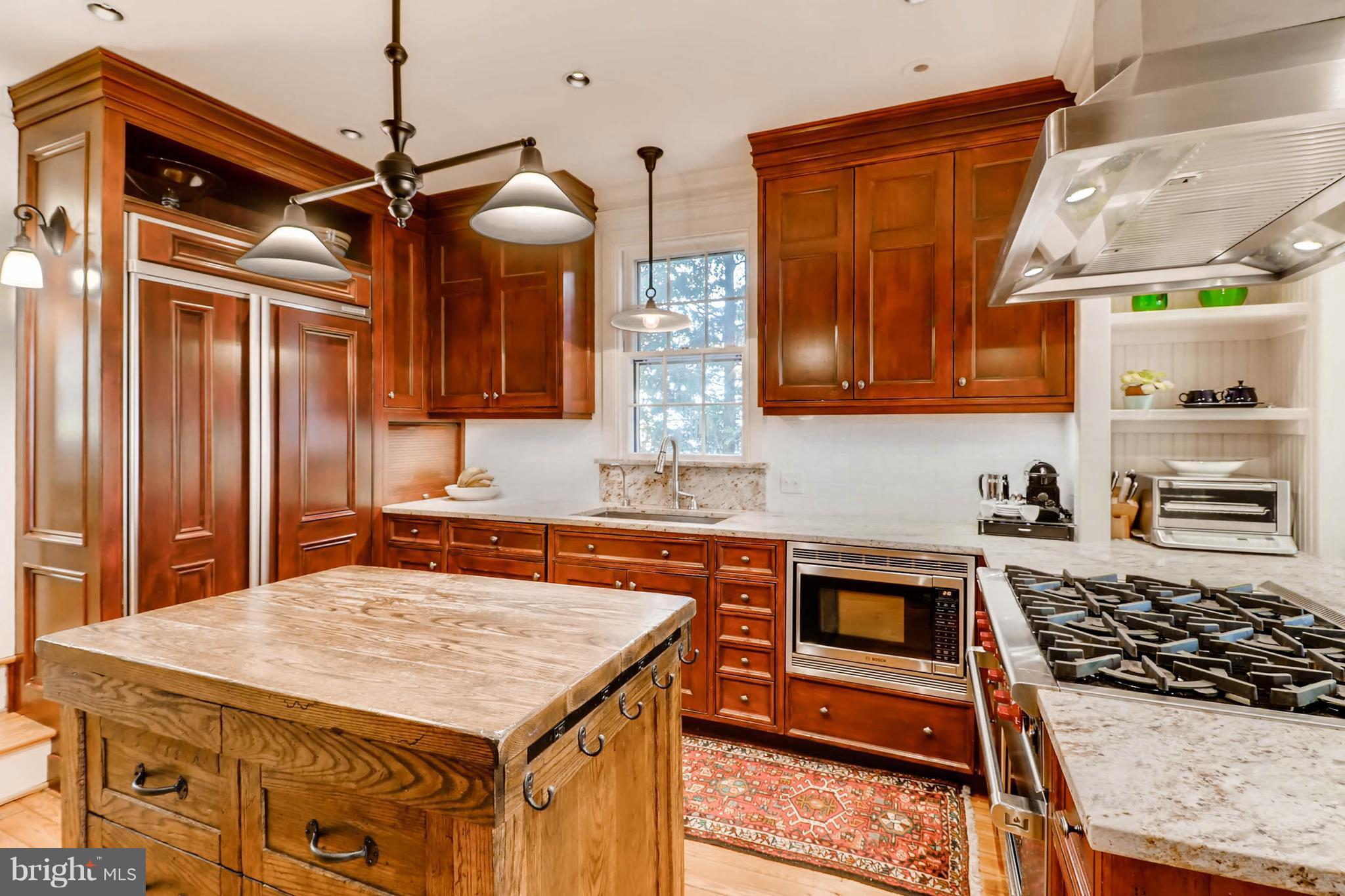 2326 Pickwick Road Baltimore, MD 21207 - Photo 10 of 30 a kitchen with a stove a sink and a wooden cabinets