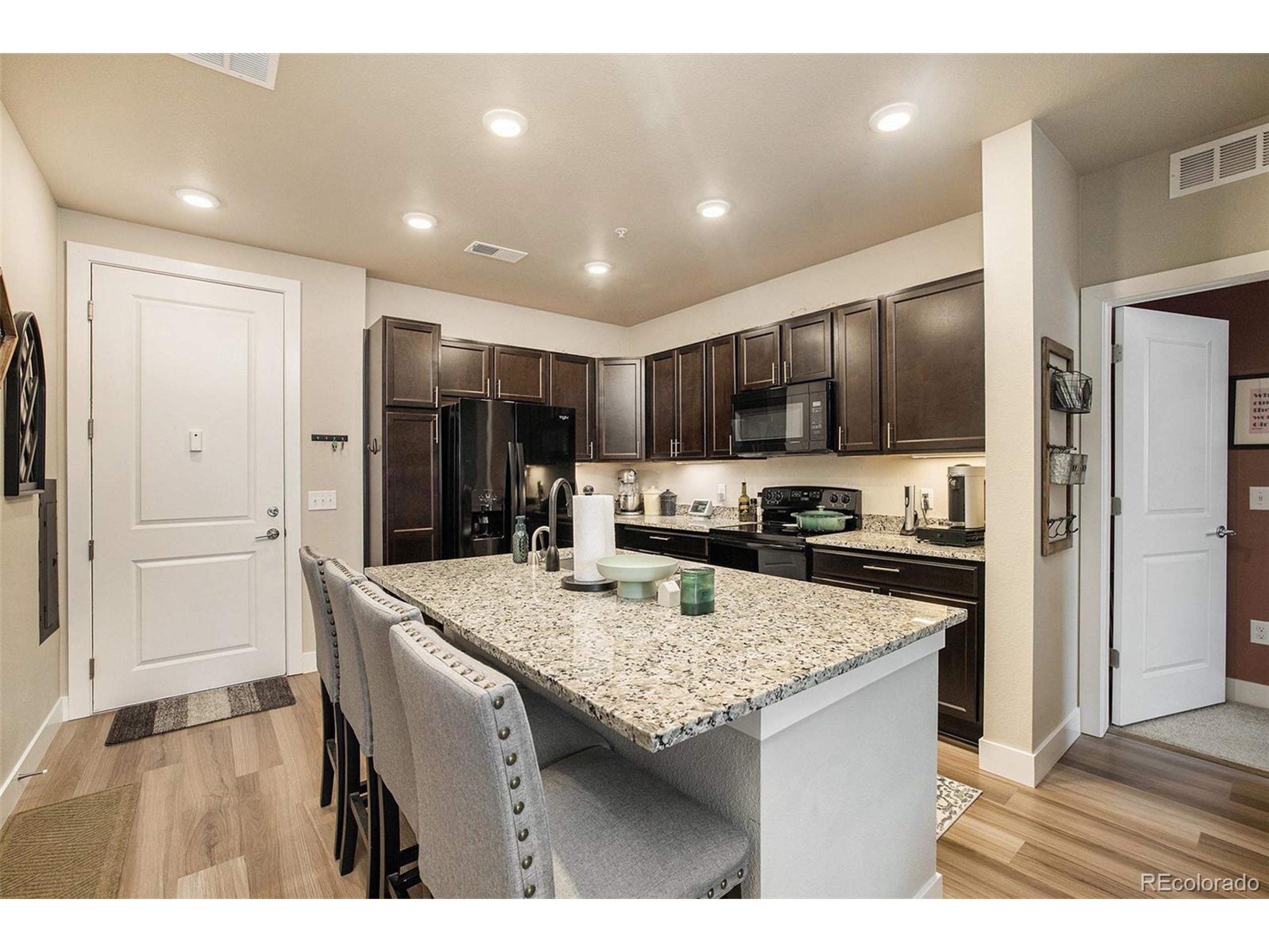 a kitchen with kitchen island granite countertop stainless steel appliances cabinets a sink and a counter