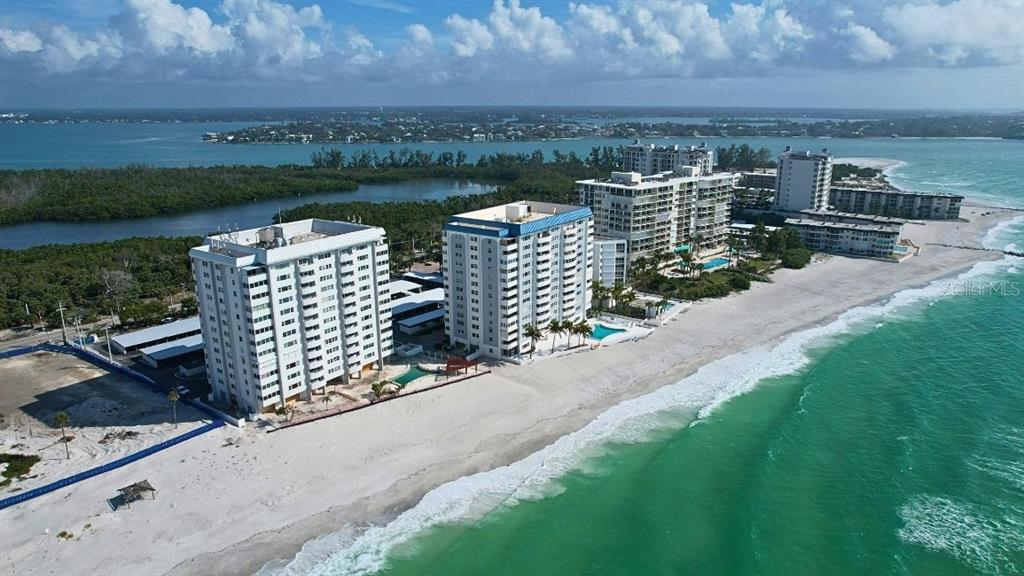 1750 Benjamin Franklin Drive, Unit 9B Sarasota, FL 34236 - Photo 1 of 47 a view of a lake with a bench in front of house