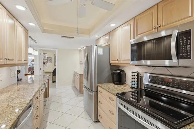 a kitchen with stainless steel appliances granite countertop a stove refrigerator and cabinets