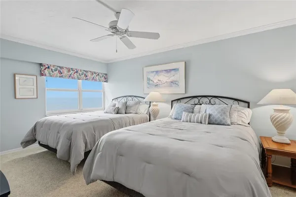 a bedroom with two beds and painting on the wall