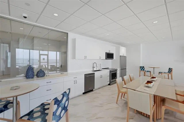 a kitchen with a sink a stove and chairs