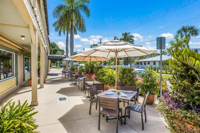 a view of a patio with couches table and chairs and potted plants
