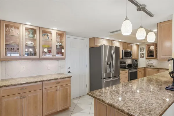 a kitchen with stainless steel appliances granite countertop a sink and refrigerator