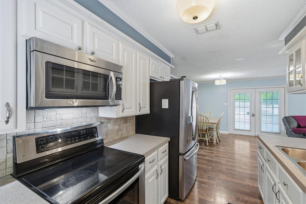 323 Rustic Road Hideaway, TX 75771 - Photo 11 of 40 a kitchen with granite countertop a refrigerator stove and microwave