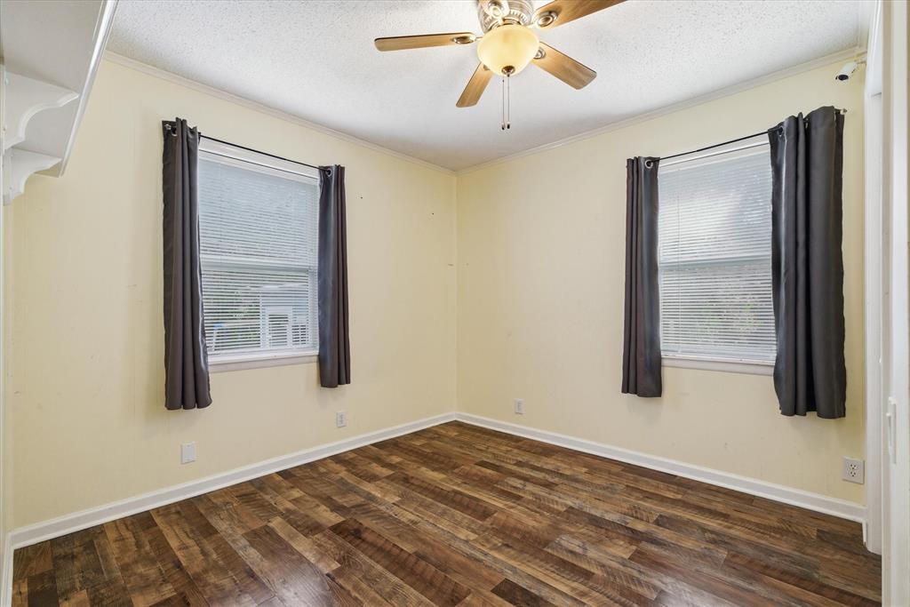 323 Rustic Road Hideaway, TX 75771 - Photo 15 of 40 a view of an empty room with wooden floor and a window