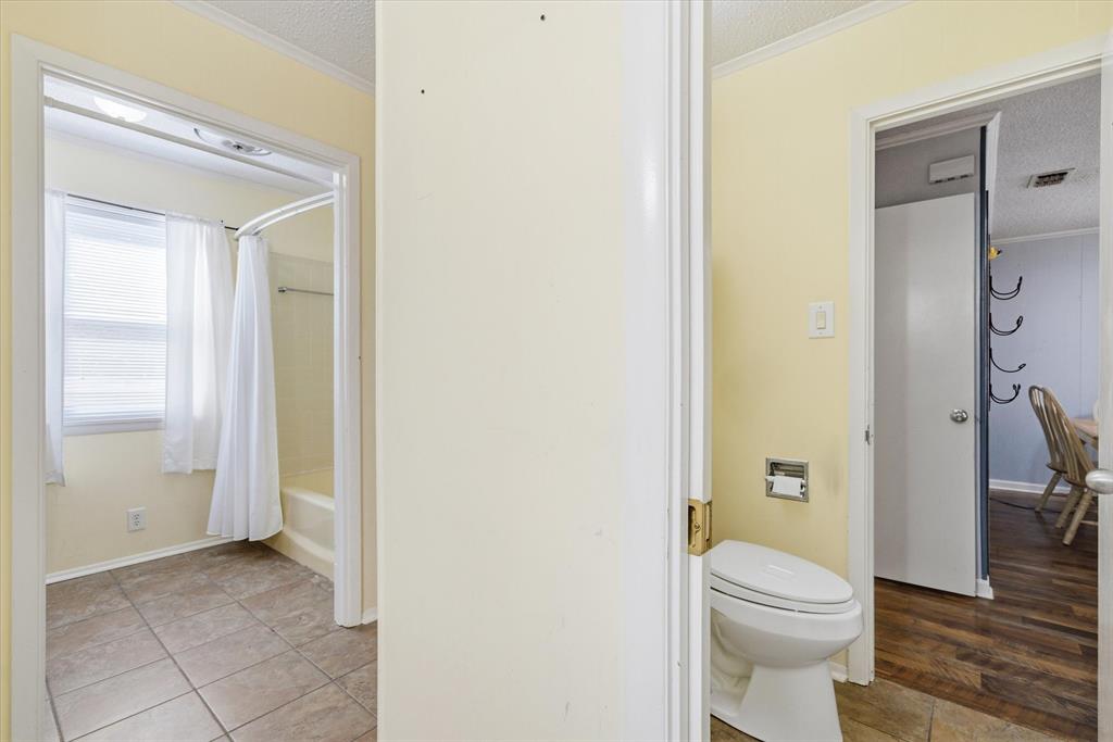 323 Rustic Road Hideaway, TX 75771 - Photo 18 of 40 a bathroom with a toilet a sink and shower