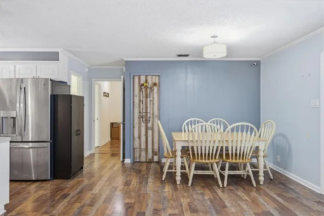 a view of a dining room with furniture a rug and wooden floor