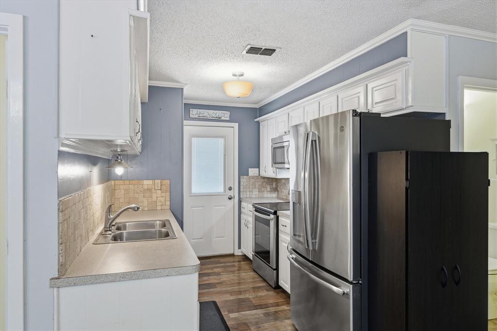 323 Rustic Road Hideaway, TX 75771 - Photo 9 of 40 a kitchen with a refrigerator sink and stove
