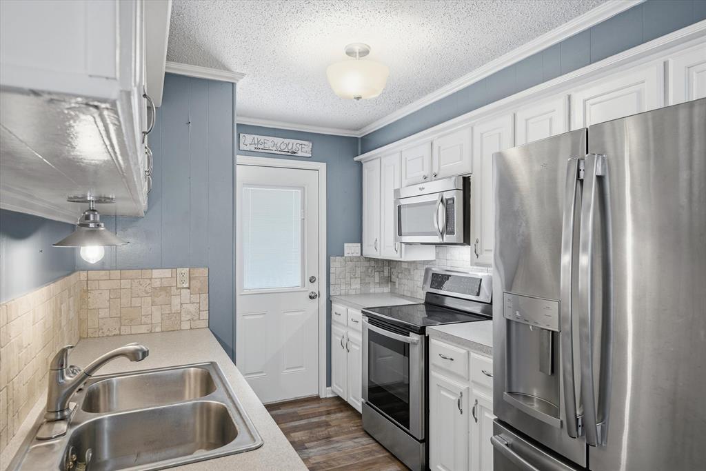 323 Rustic Road Hideaway, TX 75771 - Photo 10 of 40 a kitchen with a refrigerator sink and microwave