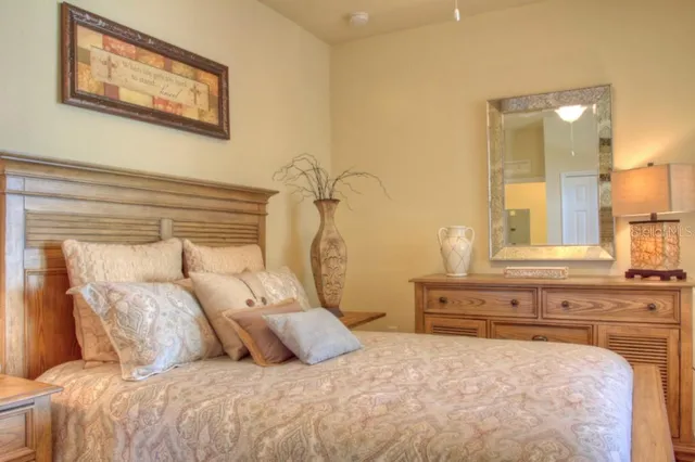 a bedroom with a large bed and a chandelier