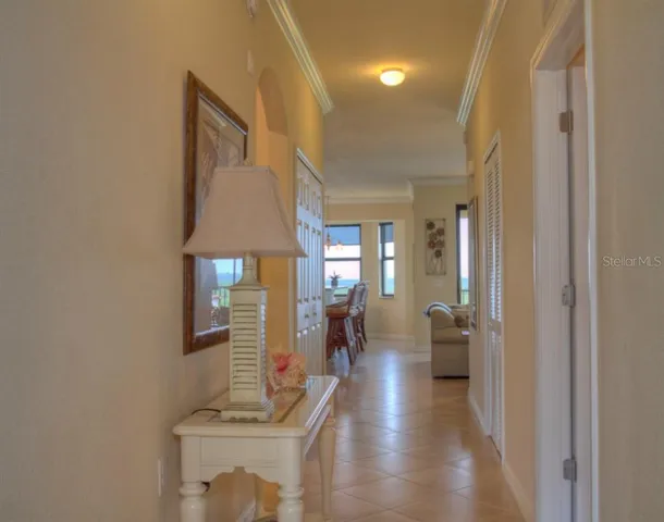 a hallway with a dining table chairs and a refrigerator