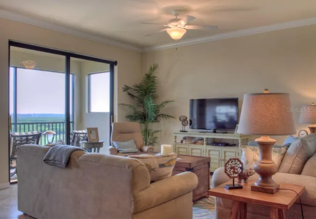 a living room with furniture a floor to ceiling window and a flat screen tv