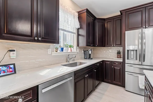 a kitchen with stainless steel appliances granite countertop a sink stove and refrigerator