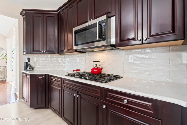 a kitchen with stainless steel appliances granite countertop a sink stove and microwave