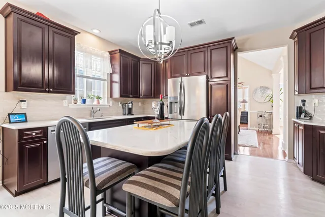 a kitchen with stainless steel appliances granite countertop a sink refrigerator and dining table