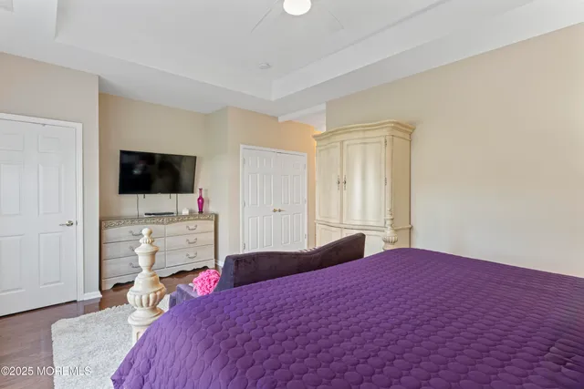 a bedroom with a bed and a flat tv screen on wall