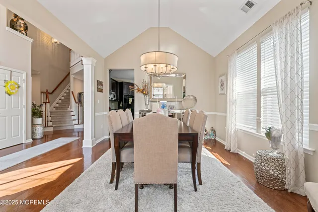 a view of a a dining room with furniture window and wooden floor