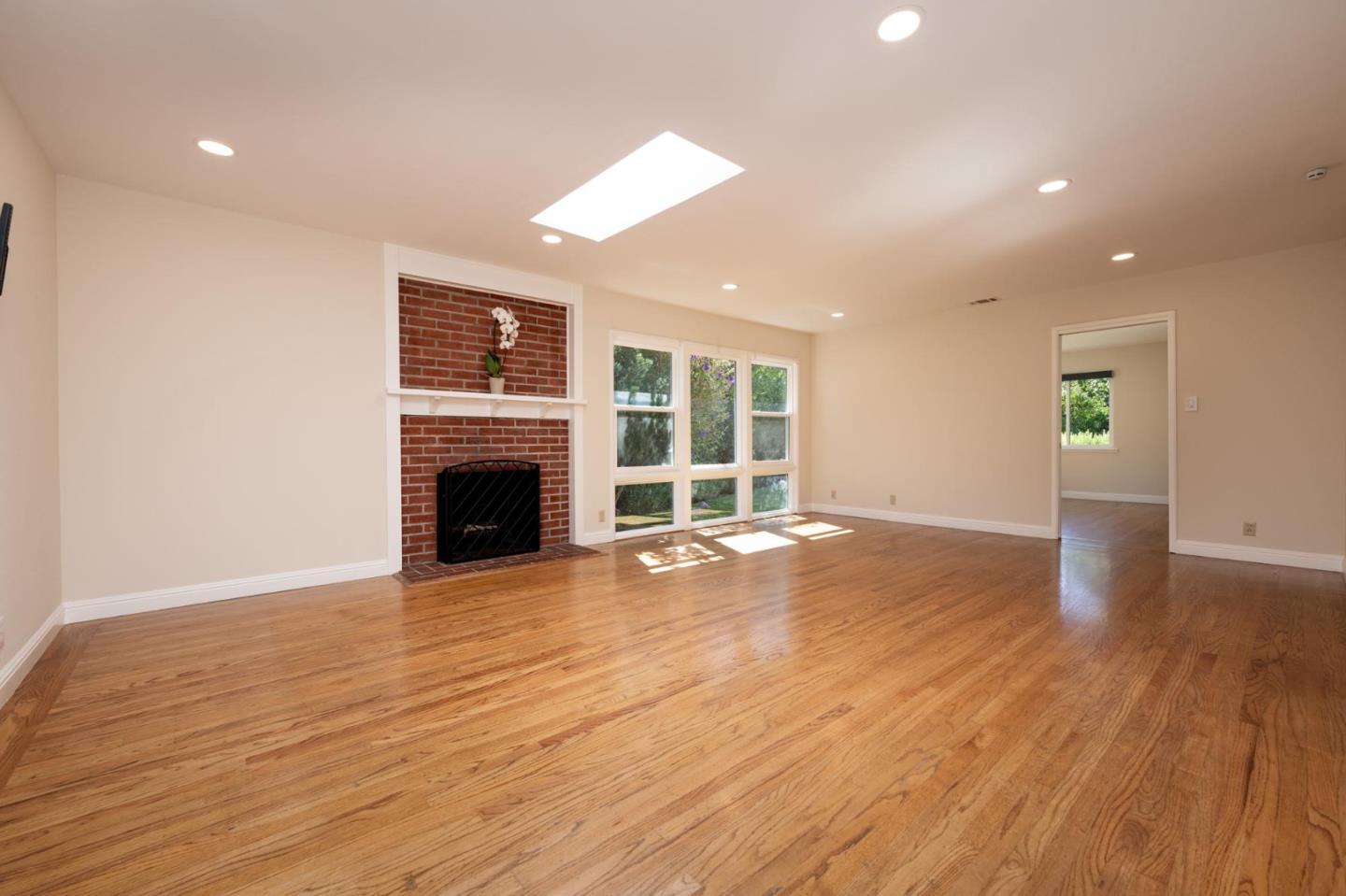 1208 Alomar Way Belmont, CA 94002 - Photo 2 of 18 an empty room with wooden floor and fireplace