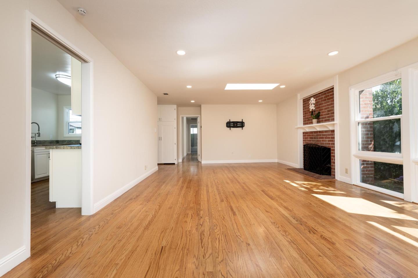 1208 Alomar Way Belmont, CA 94002 - Photo 3 of 18 a view of empty room with wooden floor and fireplace