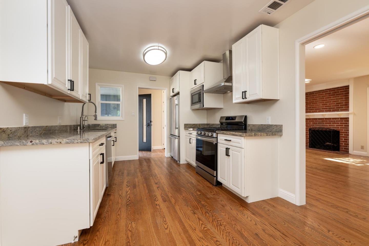1208 Alomar Way Belmont, CA 94002 - Photo 4 of 18 a kitchen with granite countertop a sink cabinets and stainless steel appliances