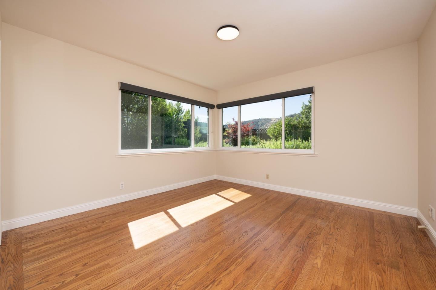1208 Alomar Way Belmont, CA 94002 - Photo 7 of 18 an empty room with wooden floor and windows
