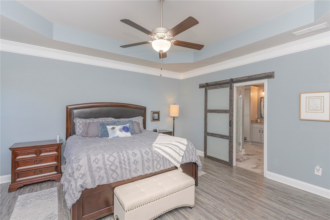 203 Graceview West Anderson, SC 29625 - Photo 23 of 50 This restful primary bedroom features a ceiling fan, crown molding, and sliding barn doors.