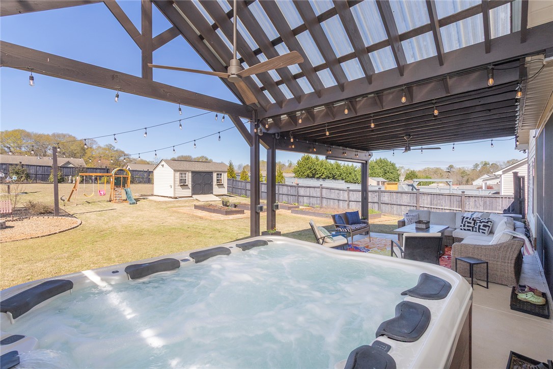 203 Graceview West Anderson, SC 29625 - Photo 33 of 50 An inviting backyard oasis features a relaxing hot tub and shaded patio for comfortable outdoor living.