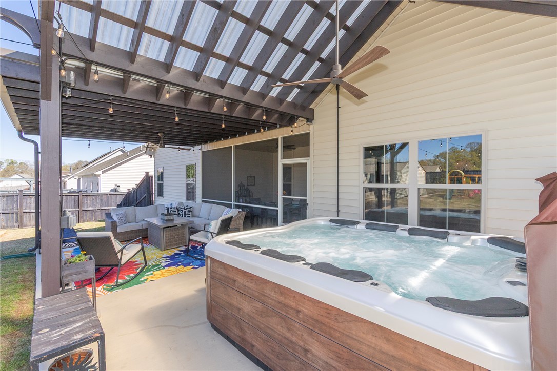 203 Graceview West Anderson, SC 29625 - Photo 34 of 50 An inviting outdoor retreat with a hot tub and comfortable seating under a shaded pergola.
