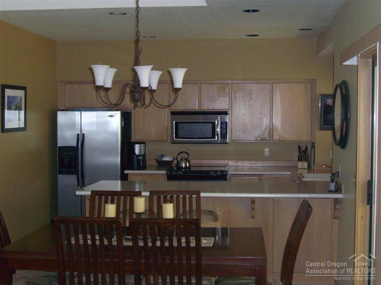 57395 Beaver Ridge Loop, Unit 40 A1 Sunriver, OR 97707 - Photo 7 of 25 a kitchen with stainless steel appliances granite countertop a refrigerator a stove and a sink with wooden floor