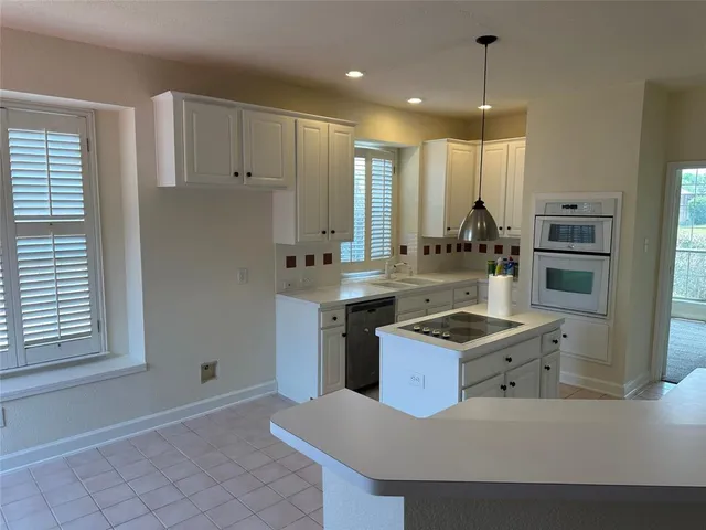 a kitchen with stainless steel appliances granite countertop a sink a stove and a refrigerator