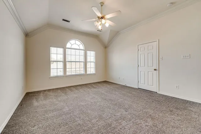 an empty room with windows and ceiling fan
