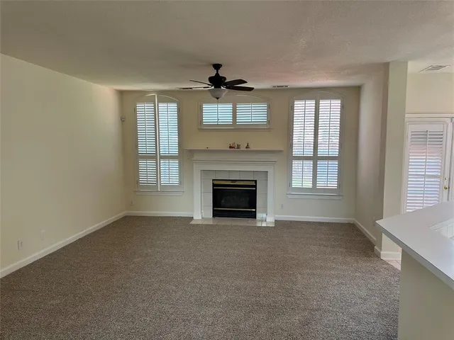 a view of empty room with a fireplace and windows