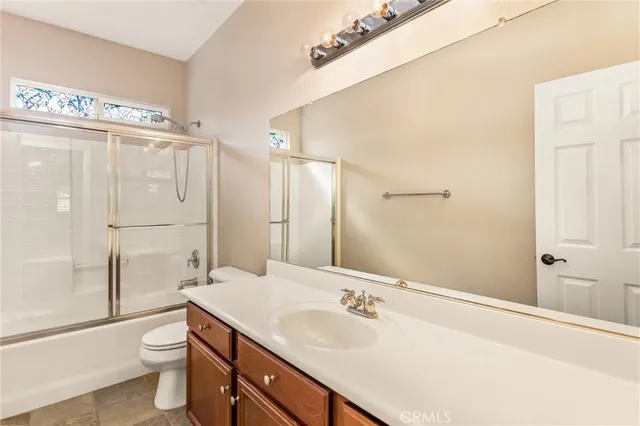 a bathroom with a granite countertop sink a mirror bathtub and shower