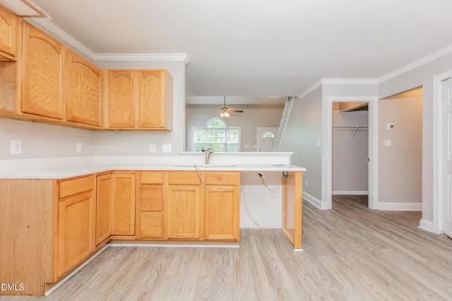a kitchen with stainless steel appliances granite countertop a sink and cabinets with wooden floor