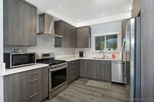 a kitchen with stainless steel appliances a stove a sink and a microwave