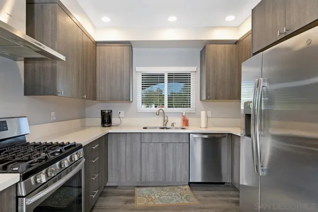 a kitchen with stainless steel appliances granite countertop a sink stove and refrigerator